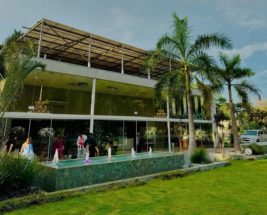 Fachada do salão do Mirante Eventos com jardim e palmeiras